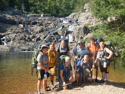 group of students with new backpacks with river background
