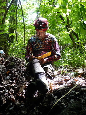 researcher at Renfro Cave writing in notebook